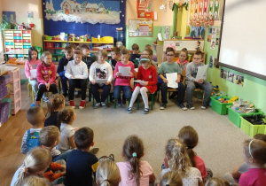 Dzieci ze szkoły czytają opowiadanie dla dzieci przedszkolnych